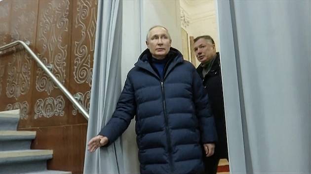 Na této fotografii pořízené z videa zveřejněného ruskou televizí v neděli 19. března 2023 ruský prezident Vladimir Putin v doprovodu ruského vicepremiéra Marata Khusnullina navštívil divadlo během své návštěvy Mariupolu