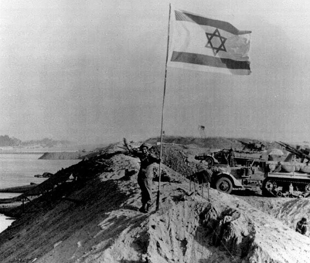 Jomkipurská válka, izraelský voják vítězně mává pod vlajkou svého státu