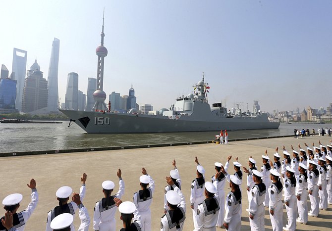 Čínští námořníci zdraví vojenskou loď v přístavu v Šanghaji. Ilustrační foto.