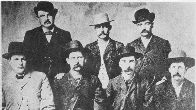 Smírčí komise Dodge City, červen 1883. Zleva doprava stojící W. H. Harris, Luke Short, Bat Masterson; sedící Charlie Bassett, Wyatt Earp, Frank McLain a Neal Brown