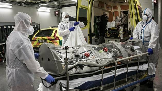 Zdravotníci přesunují pacienta s koronavirem do sanitky v belgickém Lutychu, 30. října 2020