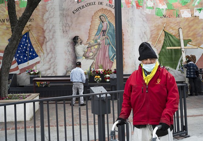 Čtyřiadevadesátiletý Tony Spinelli z Ohia prochází kolem oltáře Panny Marie Guadalupské, který je před areálem Chrámu Panny Marie Andělské v Los Angeles (na snímku z 12. dubna 2020)