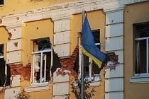 Ukrajinská vlajka na budově poškozené ruským bombardováním.