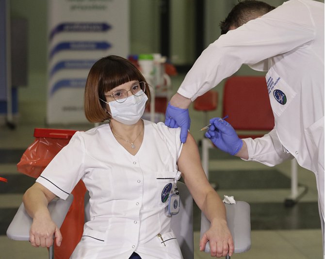 Vrchní sestra Alicja Jakubowská dostává vakcínu proti covidu-19 od lékaře Artura Zaczyńského v Nemocnici ministerstva vnitra ve Varšavě 27. prosince 2020.