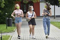 Dívky s rouškami na obličejích procházejí 20. července 2020 po ulici ve Vlčnově na Uherskohradišťsku