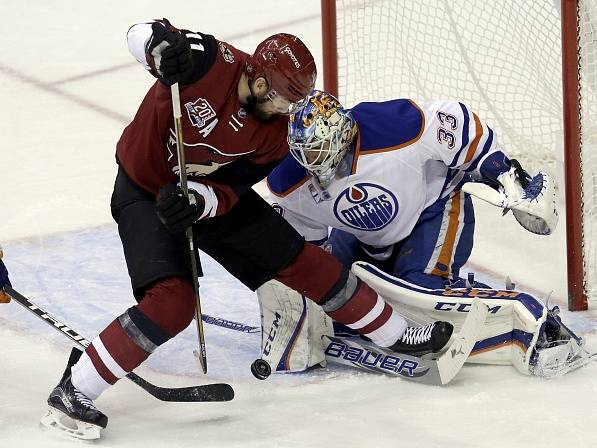 Martin Hanzal (Arizona Coyotes) a gólman Cam Talbot (Edmonton Oilers).