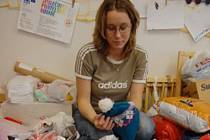 Marcela Helena Marková z Krušnohorského centra pro rodinu a sociální péči v Mostě třídí zimní oblečení darované veřejností.