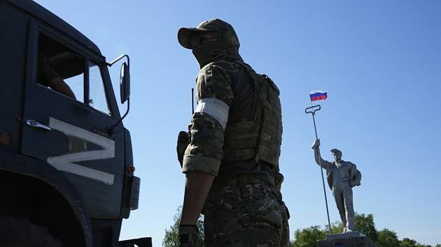 Ruský voják u nákladního automobilu v Mariupolu 12. června 2022. Ilustrační snímek
