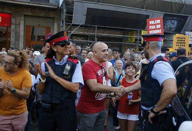 Lidé se v Madridu zdraví s policisty.