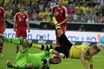 Marco Reus z Dortmundu padá přes brankáře Bayernu Mnichov Toma Starkeho poté, co vsítil gól