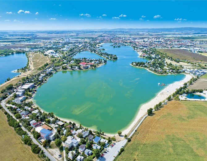 Letecký pohled na jezera u Sence nedaleko Bratislavy. Slnečné jazerá a Čiernovodské jezero dělí železniční trať.