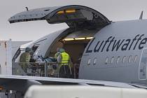 Pacienta s onemocněním covid-19 nakládají do letadla německého armádního letounu na letišti v Memmingenu 26. listopadu 2021