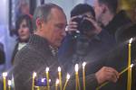 Ruský prezident Vladimir Putin zapaluje svíčku při zahájení pravoslavných Vánoc v katedrále ve voroněžském městě  Otradnoje.