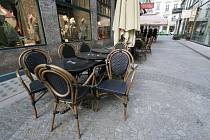 Prázdné stolky před kavárnou ve Vídni