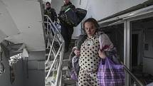 Těhotná žena utíká z porodnice v Mariupolu, kterou zasáhlo ruské bombardování