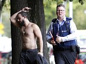 Policista doprovází jednoho z mužů, který uprchl před střelbou v mešitě v novozélandském Christchurch.