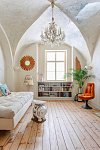 Tmavý středověký byt s bílou výmalbou a hnědým nábytkem oživil dekor oškrabaného stropu, francouzský křišťálový lustr a zařízení ve světlých barvách s barevnými akcenty. Podlaha byla zbroušena a opatřena nátěrem s bílým pigmentem.