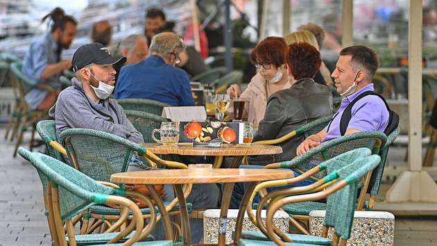 Lidé sedí 11. května 2020 na zahrádce jedné z restaurací v centru Brna. Po přestávce vynucené šířením nového typu koronaviru mohly restaurace a kavárny otevřít své předzahrádky, za další dva týdny otevřou i vnitřní prostory.