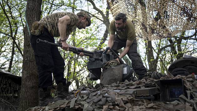 Ukrajinští vojáci montují kulomet na tank během oprav po boji s Rusy na východě Ukrajiny v Doněcku