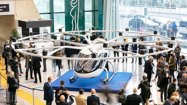 Na římském letišti Fiumicino byl představen létající taxík společnosti Volocopter. Lidi z letiště do centra Říma a zpět by takové stroje mohly už v roce 2024.