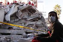 Obyvatelka Izmiru sleduje 31. října 2020 turecké záchranáře při prohledávání trosek jedné z budov po zemětřesení, které město postihlo o den dříve
