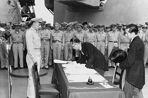 Japonský ministr zahraničí Mamoru Shigemitsu podepisuje jménem japonské vlády kapitulační listinu na palubě USS Missouri (BB-63), 2. září 1945. Generálporučík Richard K. Sutherland, člen americké armády, to sleduje z opačné strany stolu