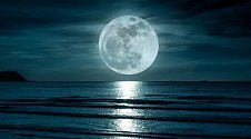 Měsíc v úplňku nad oceánem.