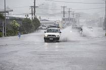 Auta projíždějí zaplavenými silnicemi ve městě Whangarei na severu Nového Zélandu 12. února 2023 před příchodem bouře Gabrielle