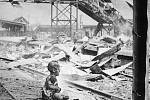 Krvavá sobota (Šanghaj, 1937). V ruinách rozbombradovaného nádraží plačící zraněné batole, jehož matka leží poblíž mrtvá. Druhá čínsko-japonská válka. Ikonický obrázek čínského fotožurnalisty H. S. „Newsreel“ Wonga 