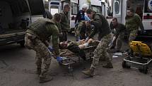Ukrajinští lékaři převážejí těžce zraněného muže.