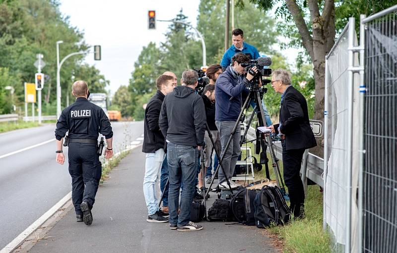 Policista prochází 29. července 2020 kolem novinářů, kteří referují o prohlídce zahrady v severoněmeckém Hannoveru v souvislosti se zmizením britské dívky Madeleine McCann. Policie v červnu 2020 v té době vyšetřovala 43letého Němce kvůli zmizení Maddie