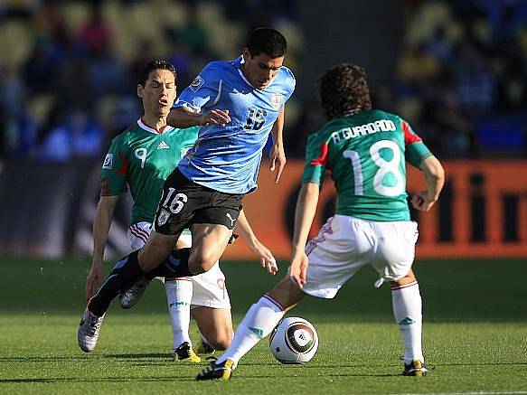 Uruguayec Pereira se probíjí mexickou obranou.