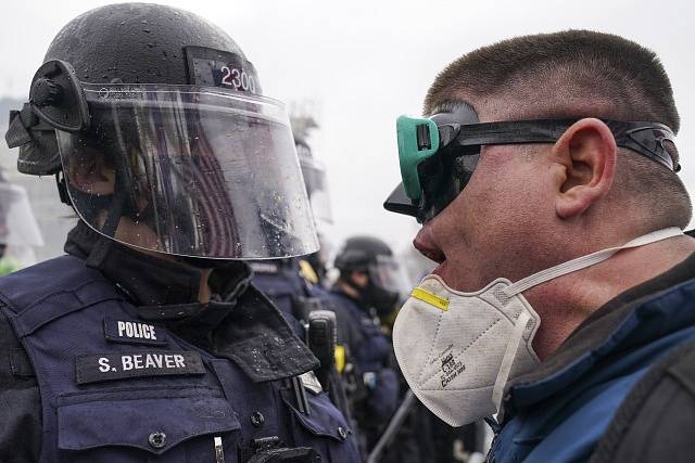 Policista tváří v tvář demonstrantovi před Kapitolem