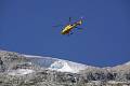 Záchranářský vrtulník nad ledovcem Punta Rocca u města Canizei v italských Dolomitech