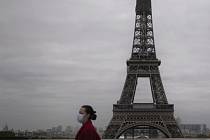 Žena s rouškou v Paříži s Eiffelovou věží v pozadí, 30. října 2020.
