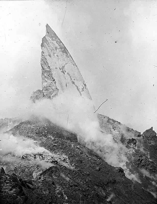 Lávový hřbet sopky Mt. Pelée, který se vynořil z centrálního kráteru v pozdější fázi erupcí v roce 1902, kolem výpary páry. Hřbet vychází z horké, krustou pokryté kupole