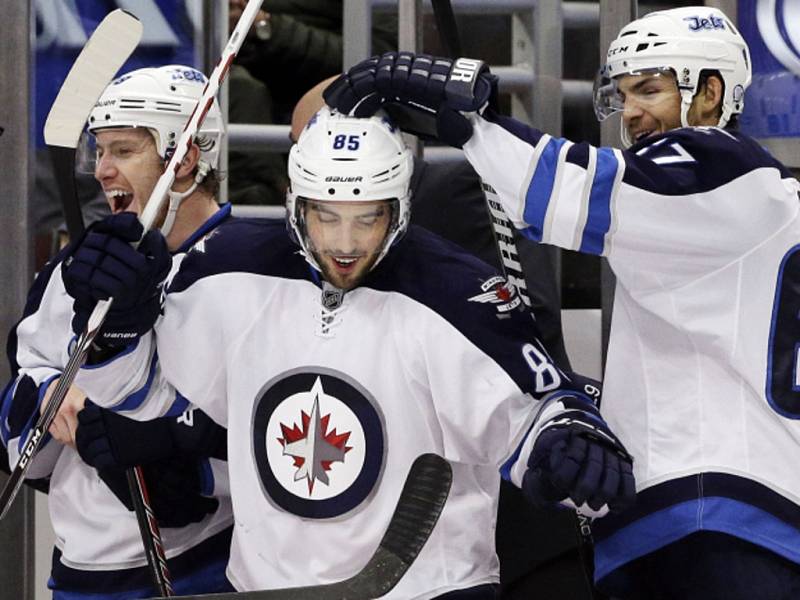 Hokejisté Winnipegu (zleva) Jacob Trouba, Mathieu Perreault a Michael Frolík se radují z gólu.