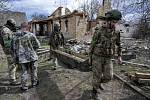 Ukrajinští vojáci vynášejí ze zničené vesnice ruské rakety.