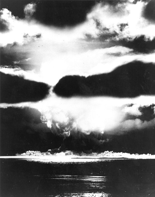 Jaderný test Sandstone Yoke. Ohnivá koule výbuchu vystoupala skrz mrakovou formaci a vyvinula se v hřibovitý mrak nad Enewetakem