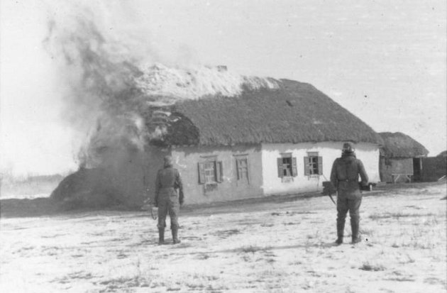 Zapalování civilních domů patřilo na východní frontě bohužel k běžně používaným metodám Waffen-SS. Na snímku dům poblíž Charkova. Dne 22. března 1943 nahnali vojáci Waffen-SS všechny obyvatele běloruské vesnice Chatyň do stodoly, kterou zapálili