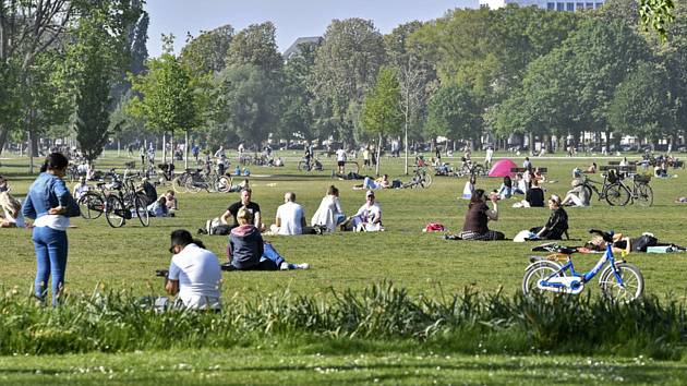 Lidé si užívají 24. dubna 2020 odpoledního slunce v parku v německém Düsseldorfu