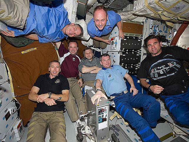 Posádka raketoplánu se fotí ve stavu bez tíže po zakotvení u stanice ISS.