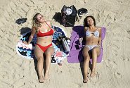Dívky se opalují na pláži. Ilustrační foto