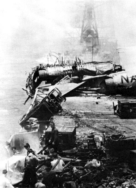 Pohled na rozbité letadlo na palubě hořící letadlové lodi USS Forrestal v Tonkinském zálivu 29. července 1967. Na snímku je i torpédoborec USS Rupertus, bojující s ohněm