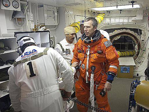 Mise STS-134, technici pomáhají připnout A. Feustelovi padák k jeho obleku.
