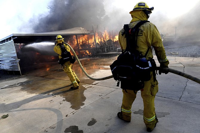 Hasiči bojují s lesním požárem v kalifornském městě Calimesa na snímku z 10. října 2019.