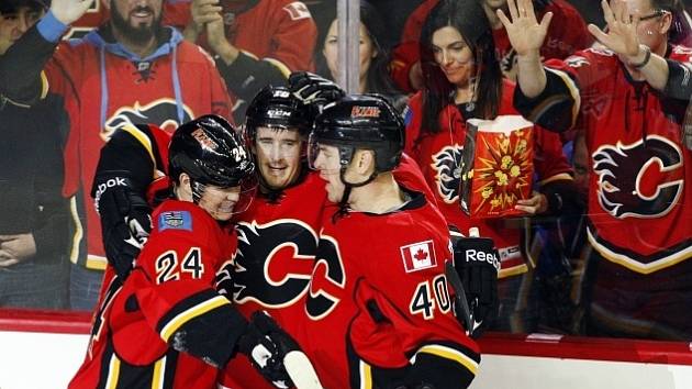 Roman Červenka (uprostřed) slaví vstřelení gólu v dresu Calgary Flames