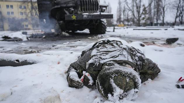 Tělo mrtvého ruského vojáka leží u zničeného automobilu v ukrajinském Charkově, 25. února 2022.