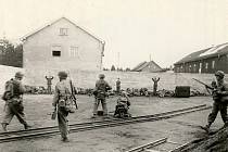 Hromadná poprava příslušníků SS u zdi, provedená příslušníky americké 45. pěší divize po osvobození koncentračního tábora Dachau