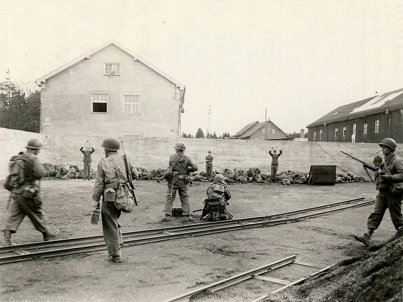 Hromadná poprava příslušníků SS u zdi, provedená příslušníky americké 45. pěší divize po osvobození koncentračního tábora Dachau